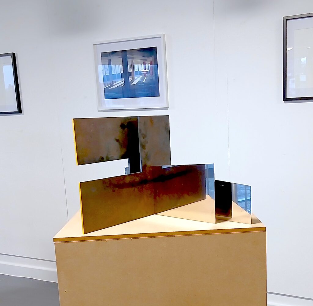 a geometric sculpture and wall image in an exhibition